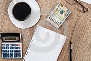 Notepad with pen, calculator, coffee and dollar