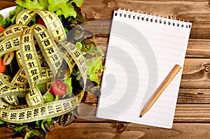 Empty notepad with vegetable salad