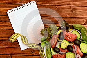 Empty notepad with vegetable salad