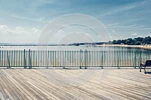 Empty ocean beach boardwalk pier at hot summer day against blue sky