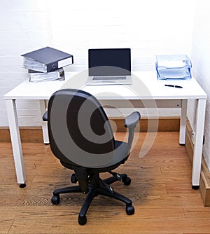 Empty office chair with laptop on desk