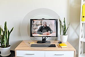 An empty office, video meeting on PC screen