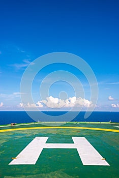 Empty oil rig helipad with few cloud and blue sky