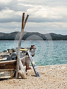 Empty old fishing boat on the shore of the sea in calm cloudy day