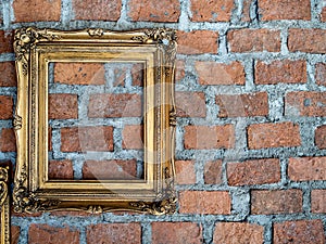 Empty old ornate golden frames hanging on brick wall