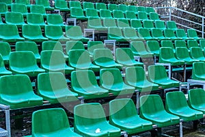 Empty old plastic chairs in the stands of the summer theater. Many empty seats for spectators in the stands of the amphitheater.