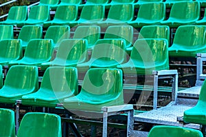 Empty old plastic chairs in the stands of the summer theater. Many empty seats for spectators in the stands of the amphitheater.