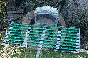 Empty old plastic chairs in the stands of the summer theater. Many empty seats for spectators in the stands of the amphitheater.