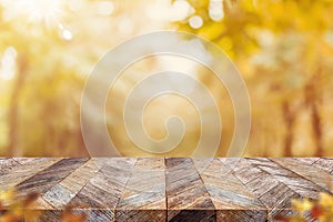 Empty old rustic wood plank table top with blur forest tree with sunlight,Autumn fall backgorund,Mock up for display or montage of