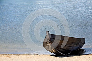 Empty old wooden rowboat on the beach