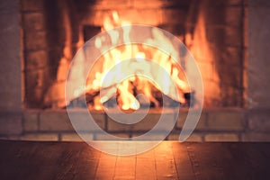 Empty old wooden table against burning wood in the fireplace