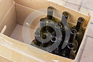 Empty olive-colored wine bottles packed in a box and prepared for bottling