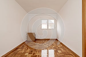 Empty one-story living room with parquet flooring of freshly stabbed and varnished oak slats and white aluminum windows