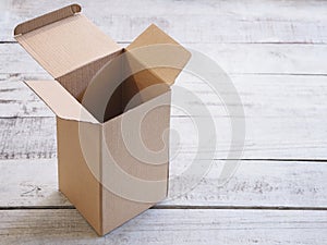 Empty opened cardboard box on wooden vintage table