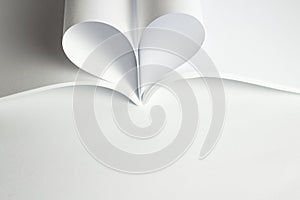 Empty opened magazine and two blank pages that becomes one heart shape. Clean photo of catalog on white background and free space