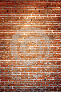Empty orange brick wall background texture with spot light in the middle.