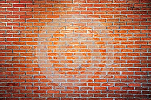 Empty orange brick wall background texture with spot light in the middle.