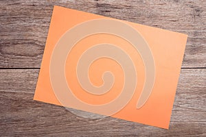 Empty orange paper on wooden table top view