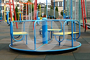 Empty outdoor children`s playground with merry-go-round in residential area