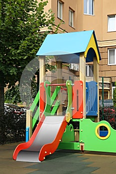 Empty outdoor children`s playground with slide in residential area