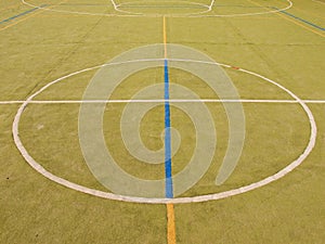 Empty outdoor handball playground, plastic light green surface on ground and white blue lines.