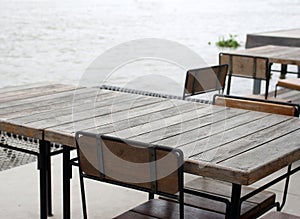 Empty outdoor old vintage wood table and chair in coffee shop restaurant near river