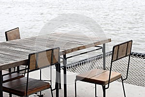 Empty outdoor old vintage wood table and chair in coffee shop restaurant near river