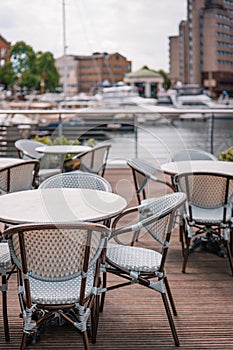 Empty outdoor restaurant tables and chairs in St Katherine\'s Dock, London, UK
