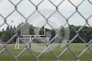 empty outdoor stadium with soccer nets yellow football goal posts and track. p
