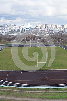 Empty oval sports stadium with running tracks and football field