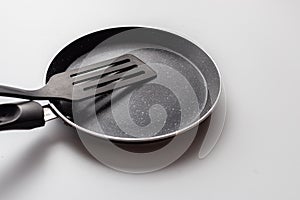 Empty pan on white background. Fried pan with spatula