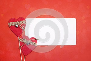 Empty paper card with decorative hearts on red background.