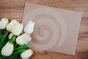 Empty paper craft with tulip flower bouquet Top view on wooden background