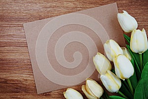 Empty paper craft with tulip flower bouquet Top view on wooden background