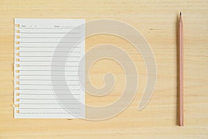 Empty paper note with pencil on wood background