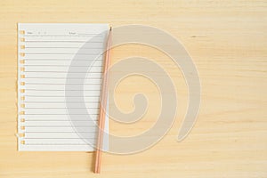 Empty paper note with pencil on wood background