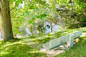 Empty park bench seat overlooking lake