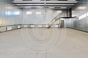 Empty parking garage, warehouse interior with large white gates and windows inside