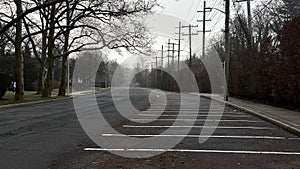 a empty parking lot with bare trees on the side of the street