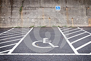 Empty parking lot with disabled parking sign on road.