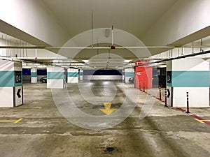 Empty parking space in a building with emergency button on the red column on the right