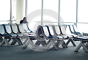 Empty passenger waiting seats in lounge after check-in next to air plane gate