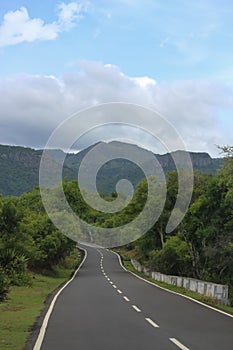 A empty peace road to the mountains clouds landscape