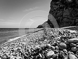 Empty pebbles beach in france on a sunny day in black and white