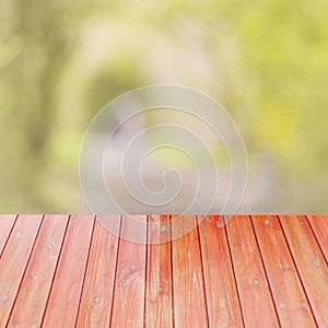 Empty perspective red wood over blurred trees with bokeh background, for product display montage