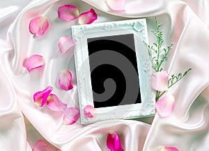 the Empty photo frame with a bouquet sweet pink roses petal on