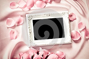 Empty photo frame with a bouquet sweet pink roses petal on sof