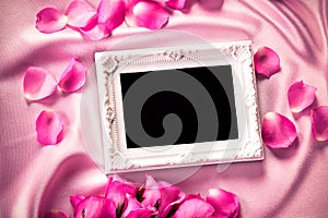 Empty photo frame with a bouquet sweet pink roses petal on sof