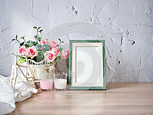 Empty photo frame candles artificial pink rose on bike toy on wood table, cement texture background, gray color ,copy space for le