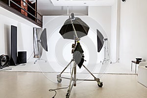 Empty photo studio with lighting equipment. Photographer workplace interior with professional tool set gear. Flash light